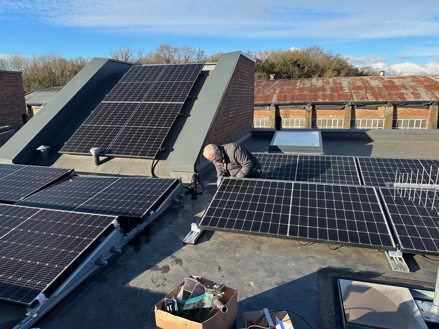 The original solar panels on the pitched dormer and the newly added flat-roof array in the foreground