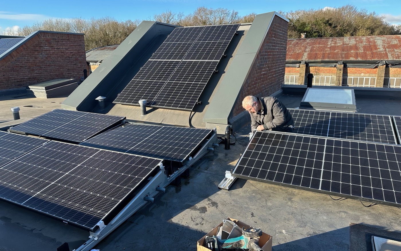New panels on tilted flat-roof mounting frames across the roof of a new build